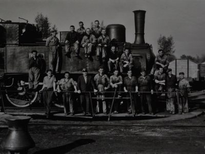 1960 circa. Fotografia ricordo della locomotiva n.1 ripresa sulla piattaforma girevole del deposito locomotive di Iseo con il personale in posa.